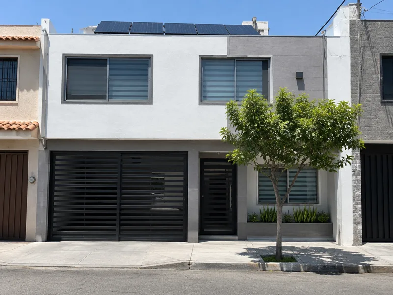 Casa de dos pisos con paneles solares en la losa